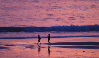 Fototapeta na wymiar Walking on the beach at sunset