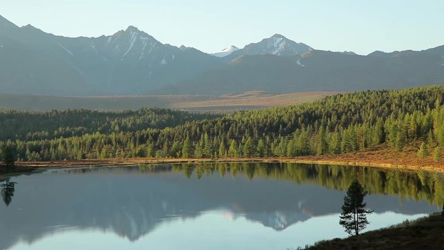 Beautiful mountain lake in Siberia against the backdrop of mountain peaks and blue sky in the summer on a sunny day. Travel to Russia.