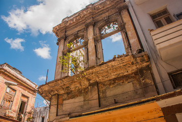 Destroyed house on the street against the blue sky with clouds. Havana. Cuba