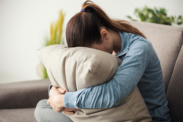 Sad woman hugging a pillow