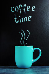 A cup with an inscription of coffee time, a pastel blue color.