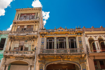 Traditional buildings in classic style with colorful facades on the background of blue sky with clouds. Havana. Cuba