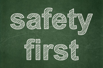 Protection concept: text Safety First on Green chalkboard background