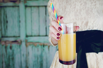 Mujer joven sujetando un vaso de zumo de naranja 