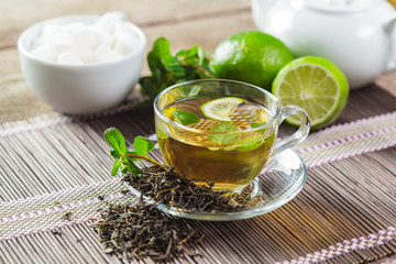 cup of black tea with mint leaves on a wooden table