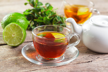 cup of black tea with mint leaves on a wooden table