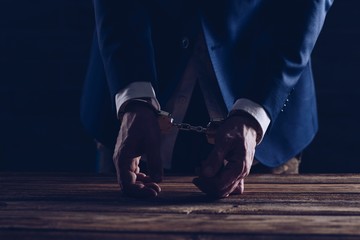 Arrested male businessman with handcuffs
