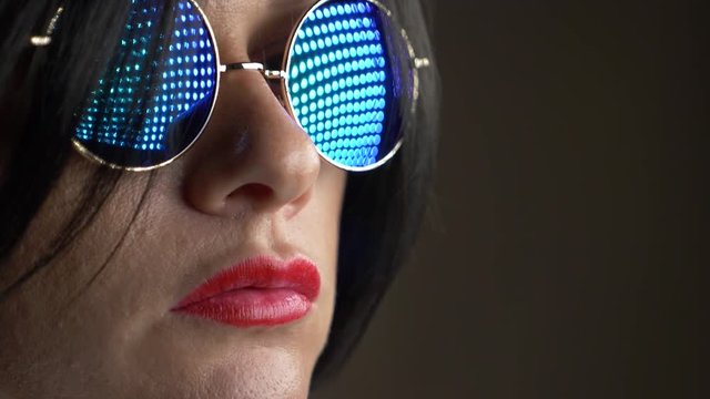 Hot brunette in round sunglasses, chewing gum and blowing a bubble. 4k, slow motion.