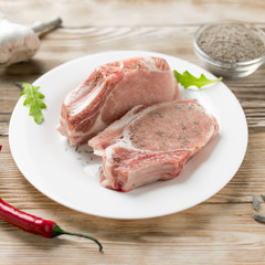 Fototapeta premium Raw pork ribs with spices on a wooden background.
