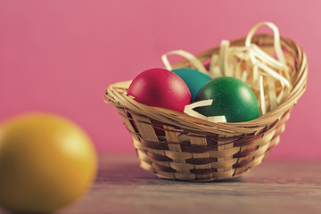 Easter basket filled with Easter Eggs over a colorful background