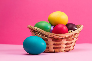 Easter basket filled with Easter Eggs over a colorful background