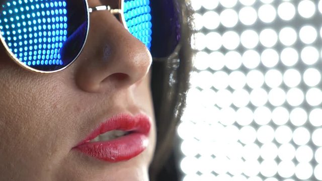 Hot brunette in round sunglasses, chewing gum and blowing a bubble. 4k, slow motion.