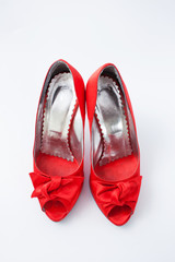 red female shoes with a bow on a white background 