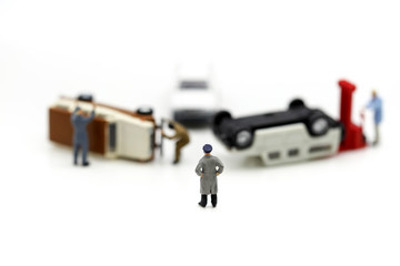 Miniature people : people with car crash accident damaged.