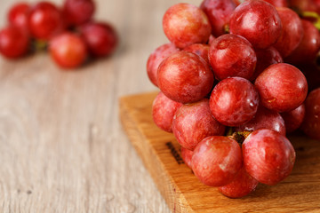 Red grapes on wooden table