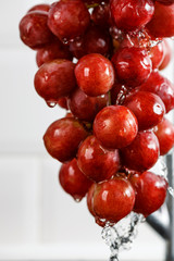 drops of water flow down from a bunch of red grapes