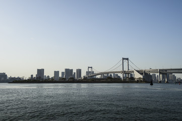 Fototapeta na wymiar Tokyo Bay with Rainbow Bridge in Background at Dusk