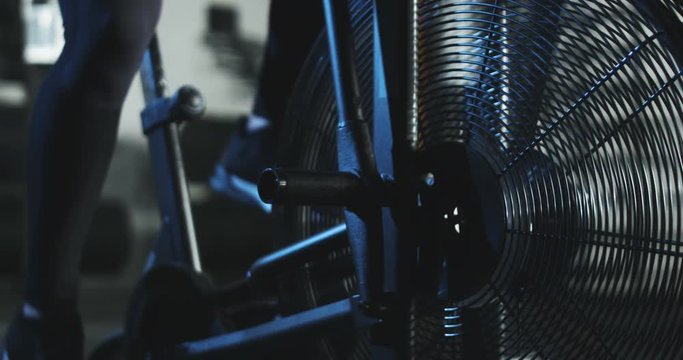 Close-up view of working process of gym exerciser air bike with flying blades.