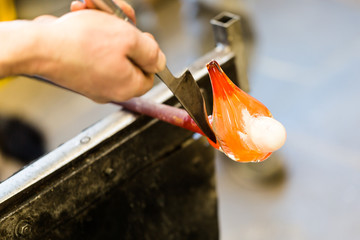 Glass artist works on seagull sculpture made from hot glass