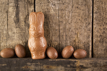 Chocolate easter eggs and bunny on wooden backgroudn. Copy space.