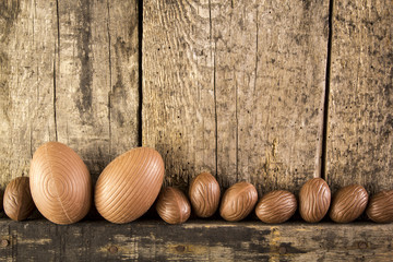 Chocolate easter eggs on rustic wooden background. 