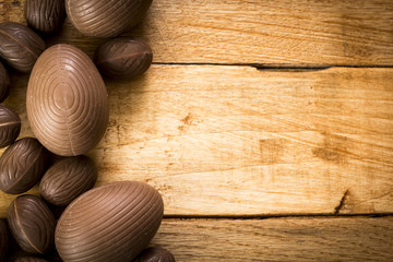 Chocolate easter eggs on wooden table. Top view. 