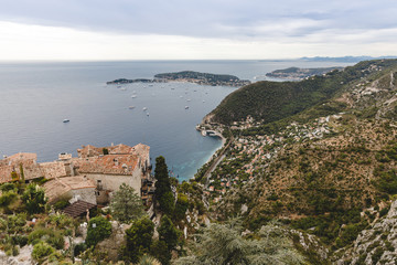Fototapeta na wymiar aerial view of european city located on hills by seashore on cloudy day, Eze, France