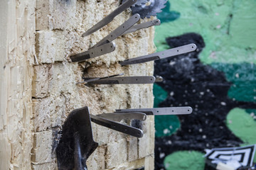 The throwing knives, the sapper shovel and the disks from the circular saw are stuck in a wooden target. Close-up photo