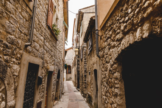 narrow street with ancient stone buildings at old european town, Peille, France