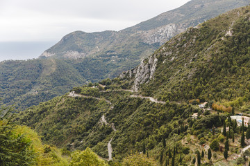 Fototapeta premium aerial view of curved mountain road on cloudy day, Sainte Agnes, France