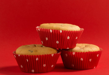 three muffins with red moulds on a red background