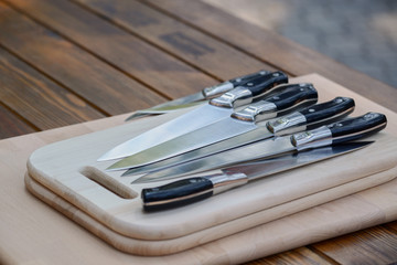 set of steel knives on a wooden board