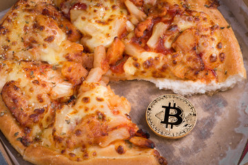 Bitcoin pizza day, physical golden bitcoin coin symbol and the pizza, future concept financial currency, crypto currency sign