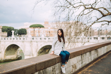 Fototapeta premium Young girl stands and looks forward to the spring city