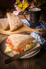 Triangular sandwich with cheese, ham and tomato.