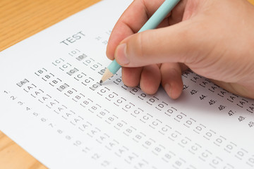 filling test score sheet with a pencil