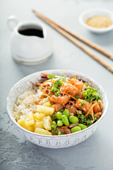 Poke bowl with raw salmon, rice and vegetables