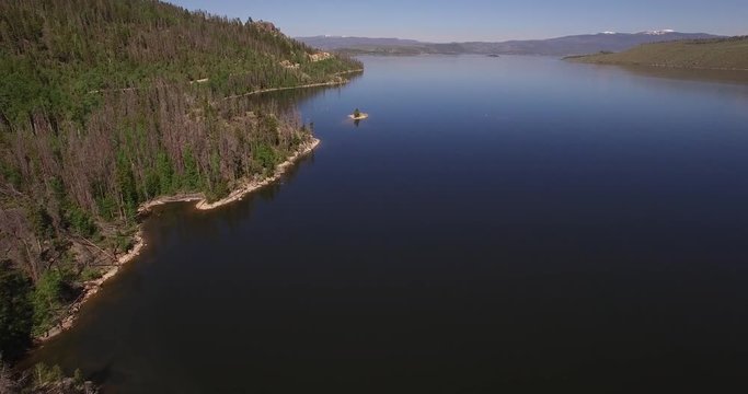 Flying over lake granby near shore - Drone Aerial Video 4K Colorado Rocky Mountains, Colorado river, Mountain dam at lake granby,  beautiful water reflection, spring, pristine water, foliage,