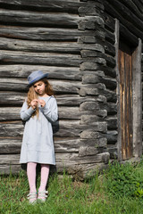 Joyful teen girl in casual clothes and blue hat posing by a wooden wall. Active lifestyle. Youth fashion