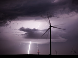 Thunderstorm with lightnings over a wind farm - 198618144