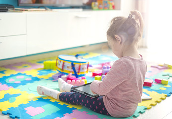 Fototapeta premium little girl is using a digital tablet