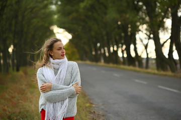  Beautiful girl hugging myself, cold on outdoor, standing near road on nature, autumn