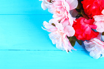 Pink peonies on a blue wooden table. Postcard for the holiday. Copy the space. Top view.