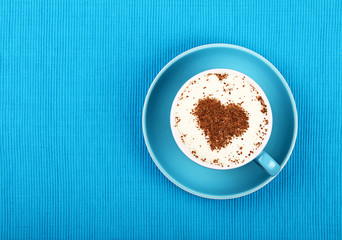 Close up latte cappuccino coffee in cup on blue