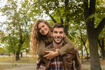 Obraz premium Handsome man carrying his attractive girlfriend on the back