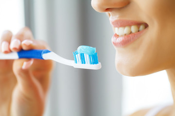 Beautiful Smiling Woman Brushing Healthy White Teeth With Brush. High Resolution Image