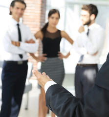 background image of businessman holding out hand for a handshake.