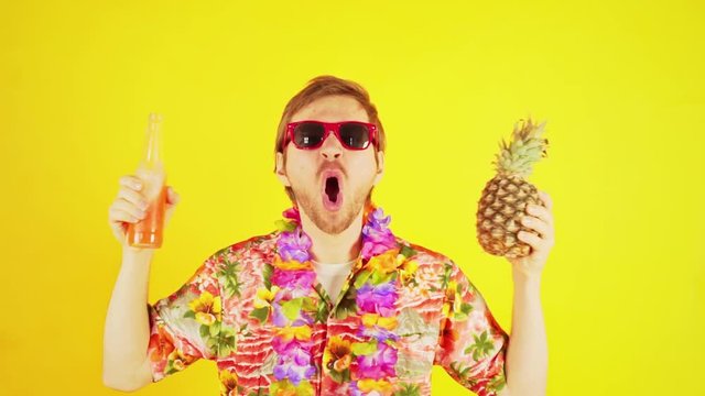 Funny crazy tourist man in hawaiian shirt with pineapple and orange soda drink having fun