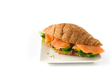 Croissant sandwich with salmon and vegetables isolated on white background

