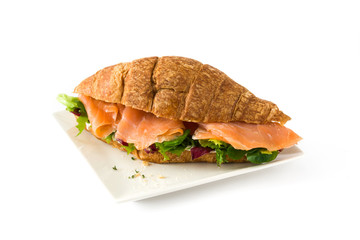 Croissant sandwich with salmon and vegetables isolated on white background

